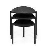 Close-up of three black teardrop nesting tables showing wood grain tops and matte metal legs on cream rug.