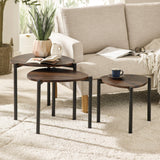 Three dark wood teardrop nesting side tables arranged in front of beige fabric sofa on white rug in living room.