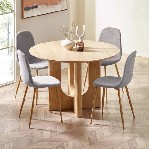 Round oak dining table with four grey fabric chairs in modern dining room