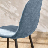 Blue fabric dining chair with curved back and dark wooden legs on light wood floor