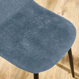 Blue fabric dining chair seat with black legs on light wood floor
