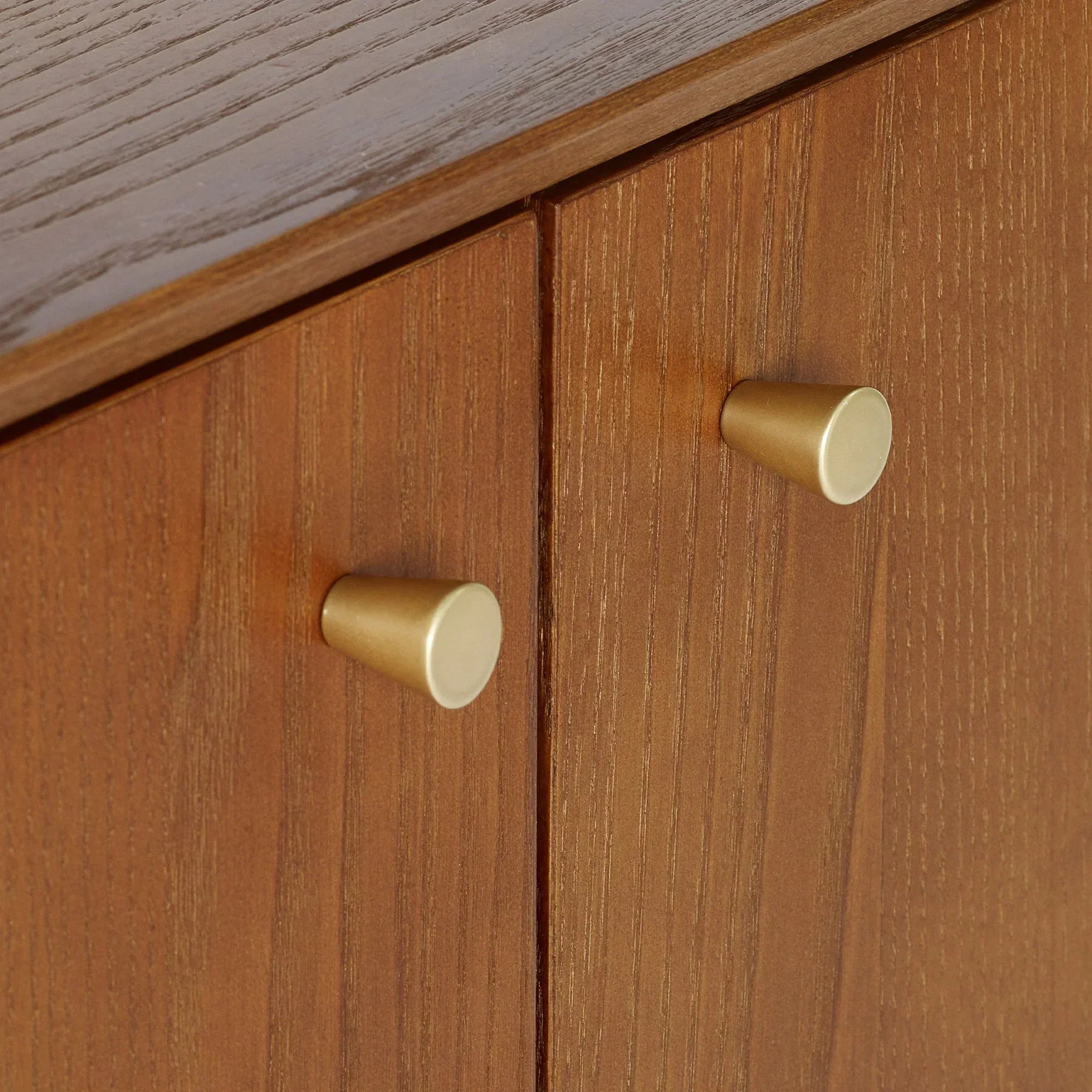 Small sideboard wood grain detail with gold handles and textured cabinet doors