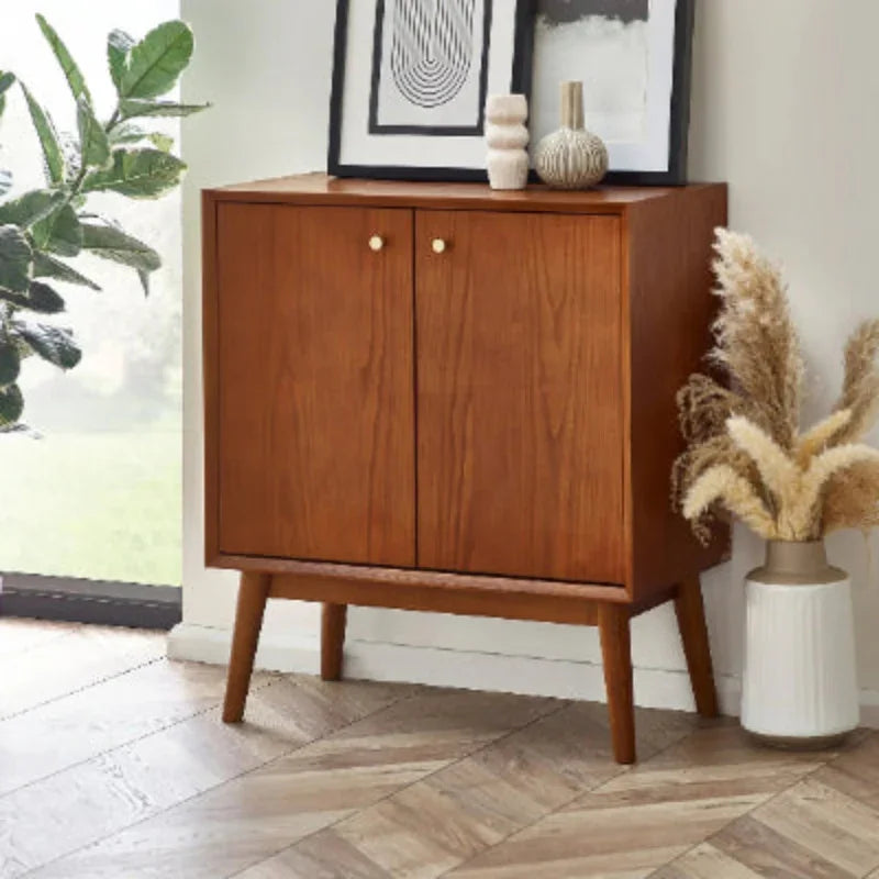 Small sideboard with wood finish and gold knobs in styled living space