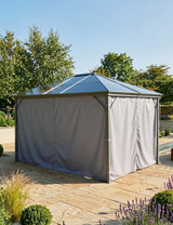 Garden gazebo with metal frame and closed grey curtains on stone patio