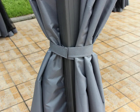 Grey outdoor gazebo curtain tied to metal frame on tiled patio