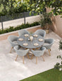 Grey rattan outdoor dining set with round table and six chairs on patio