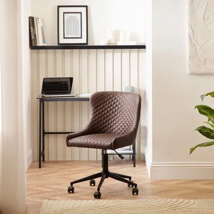 Brown quilted swivel office chair with black metal base in modern home workspace