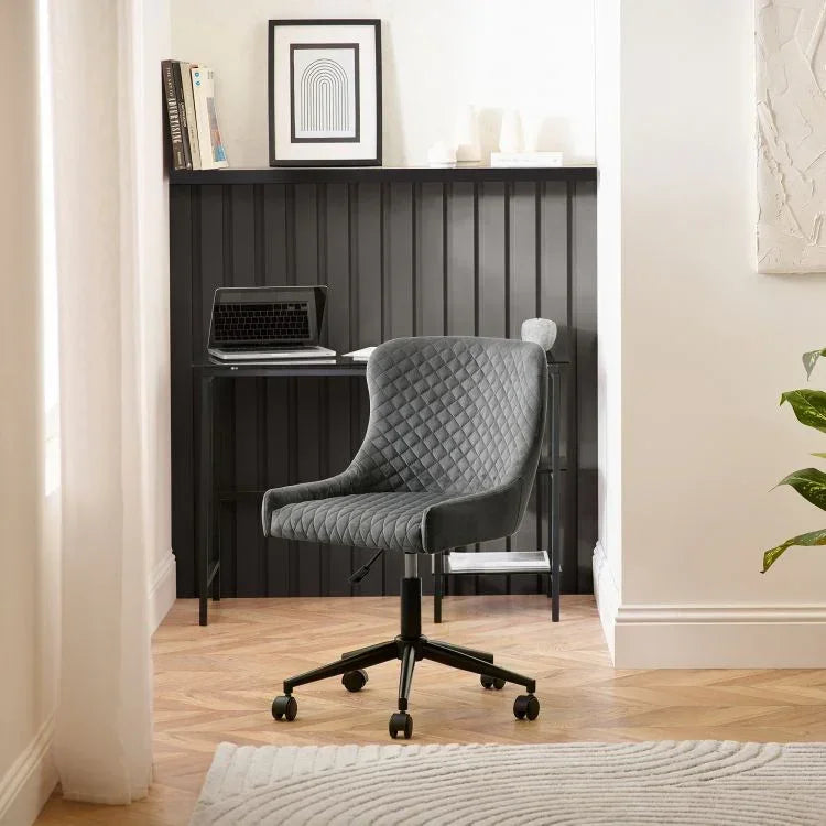 Grey velvet office chair with diamond stitching on swivel base in modern home workspace