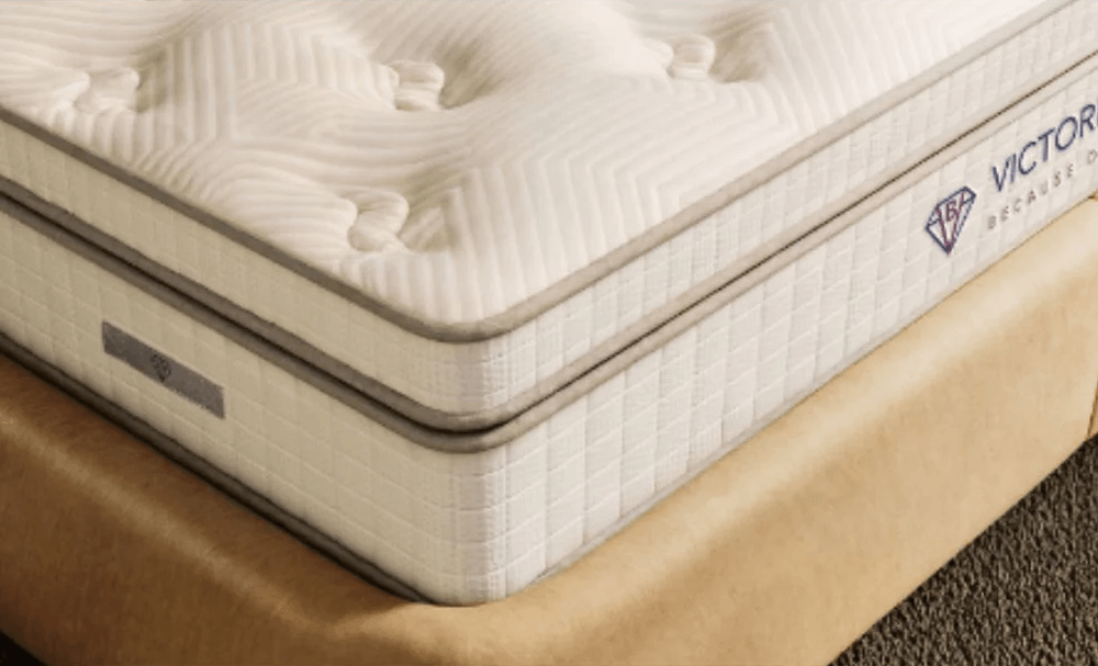 Cream mattress corner showing stitched side panels and cushioned top surface