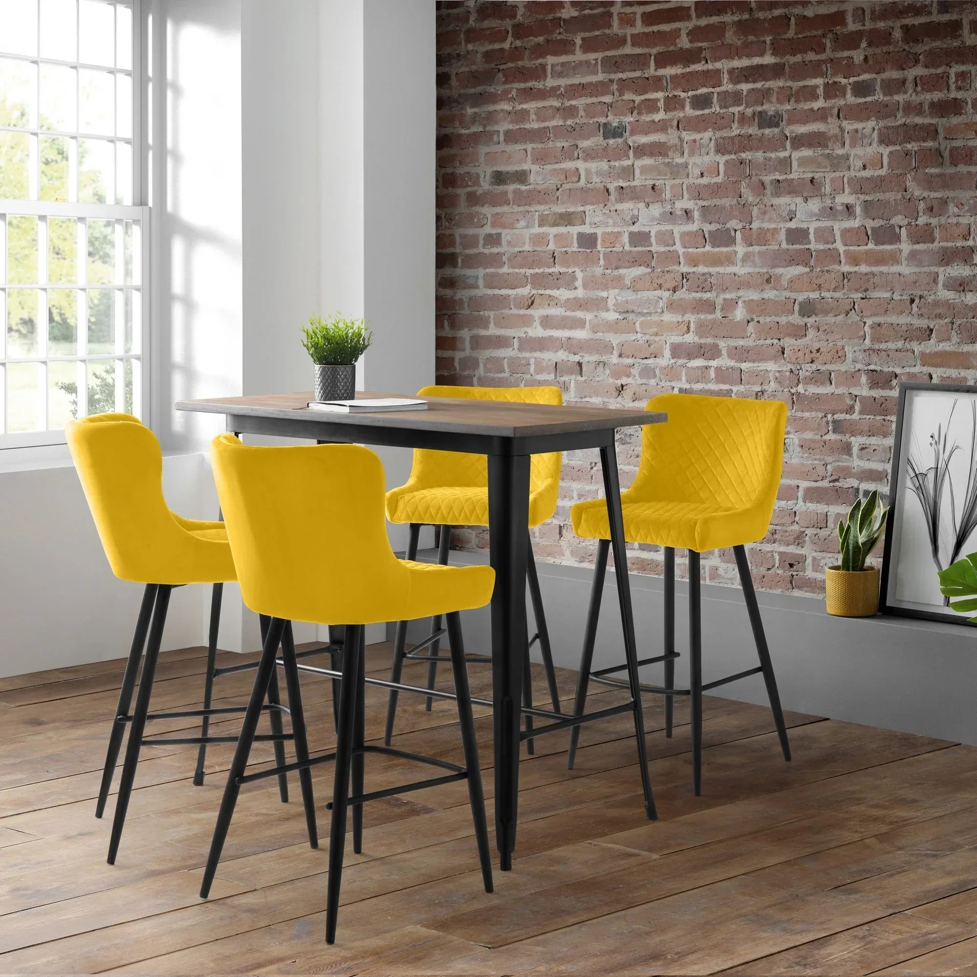 Mustard bar stools with quilted backs around tall black table in loft dining area