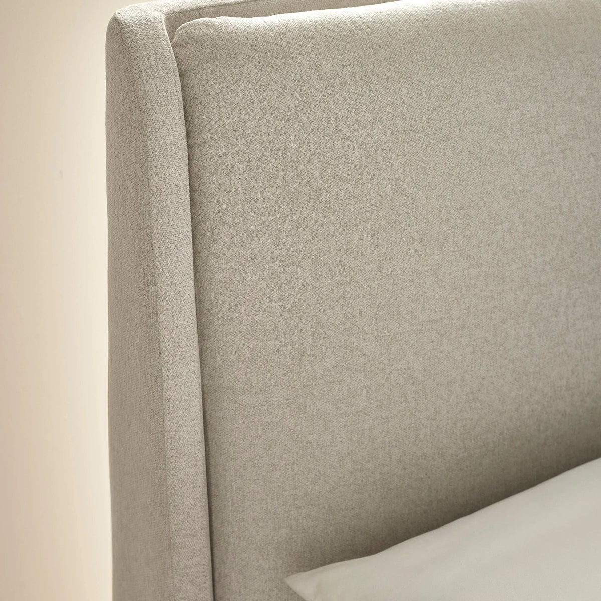 Light grey upholstered bed headboard with textured fabric and clean straight edges