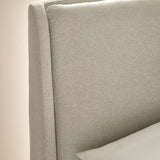 Close-up of beige fabric headboard with seam detail and white pillow
