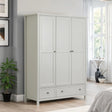 White wooden wardrobe with three doors and two drawers in modern bedroom