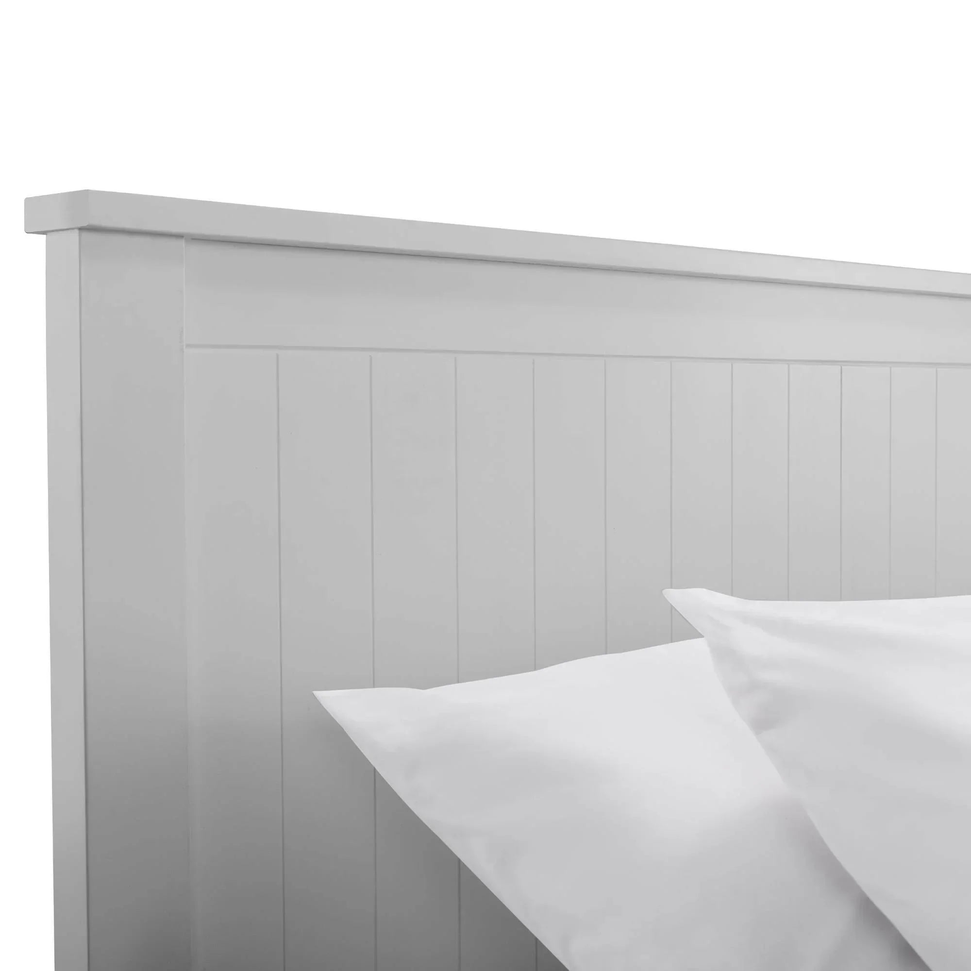 White wooden bed frame with vertical panel headboard and two white pillows