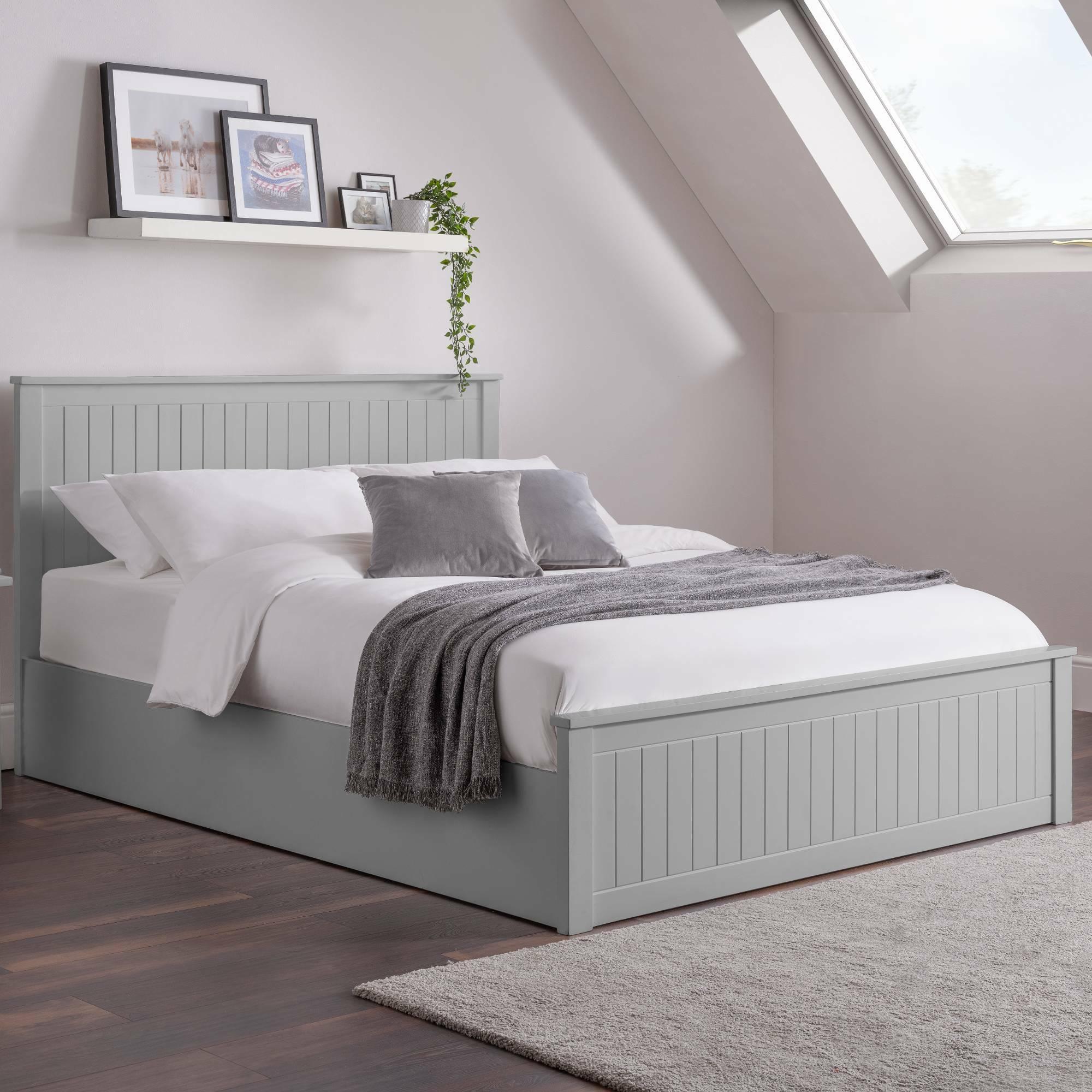 Grey wooden bed frame with vertical panel design, white bedding and grey throw blanket