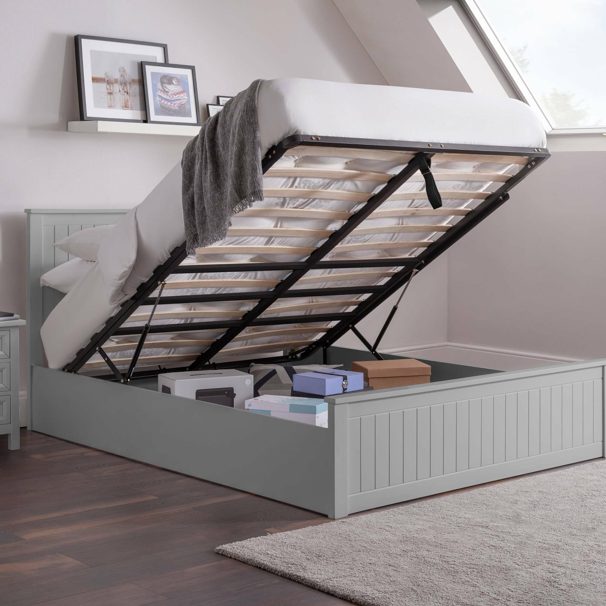 Grey ottoman storage bed with raised slatted base showing storage space and boxes