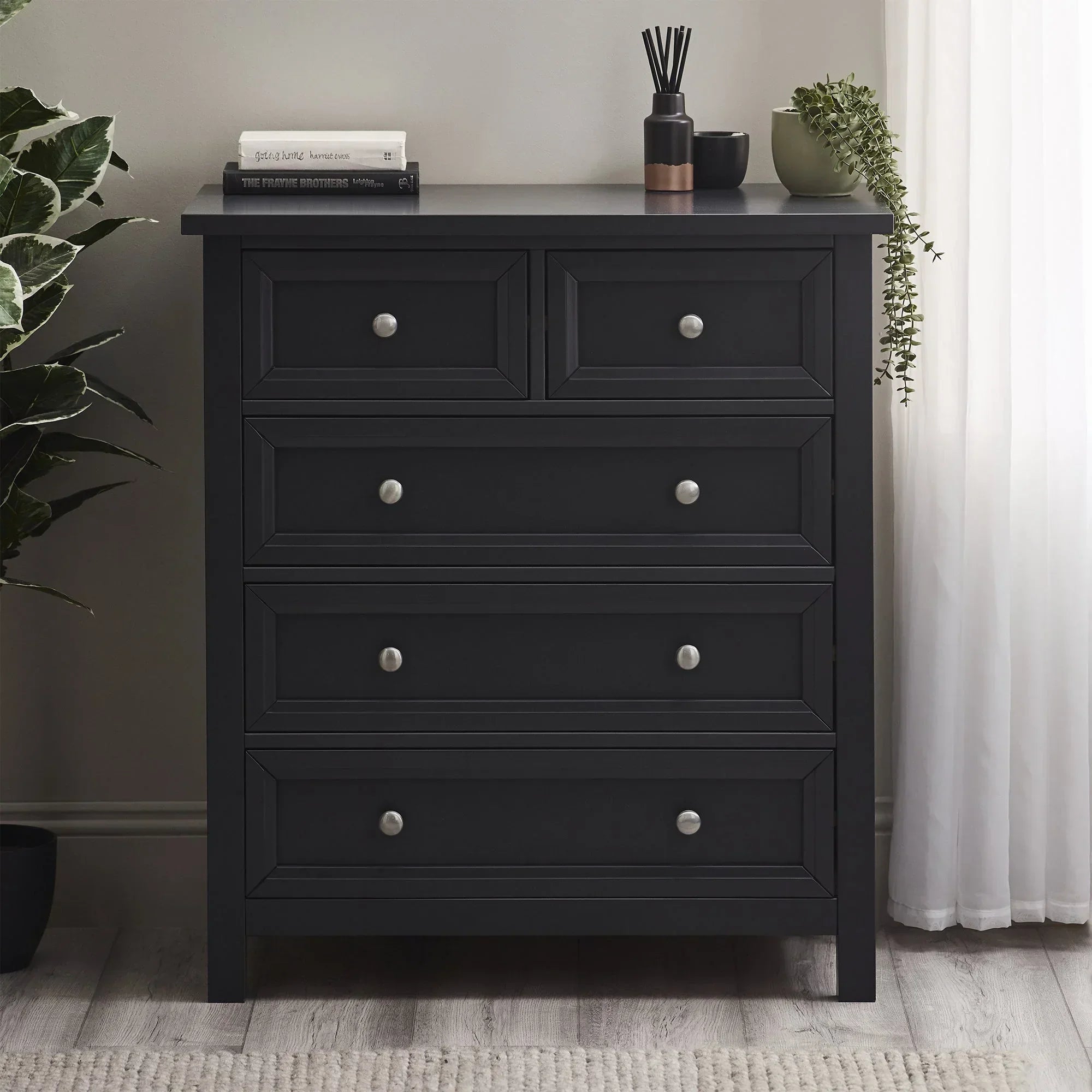 Anthracite two drawer chest with silver knobs, styled with books and decor in modern bedroom