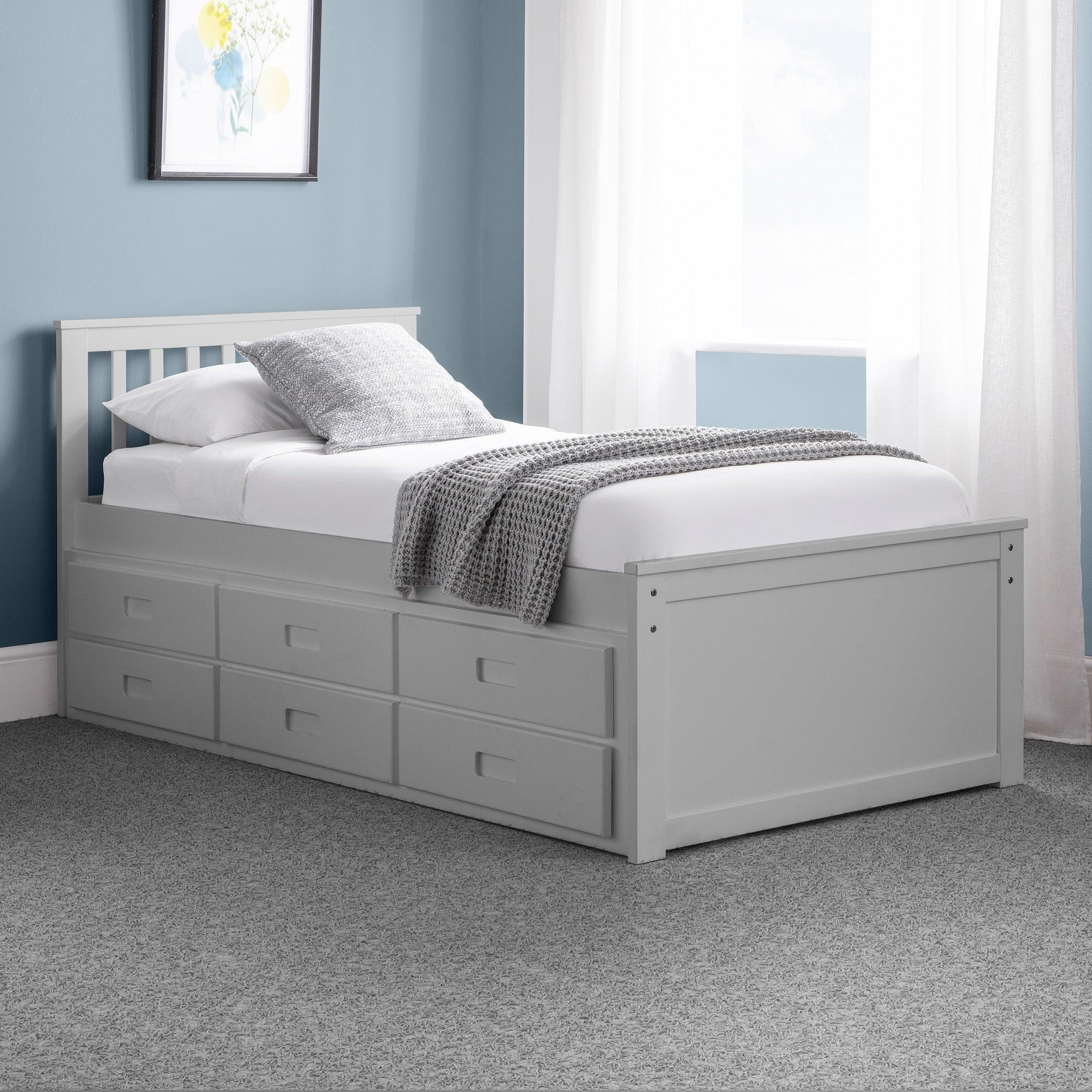 Light grey single daybed with storage drawers in a modern bedroom setting