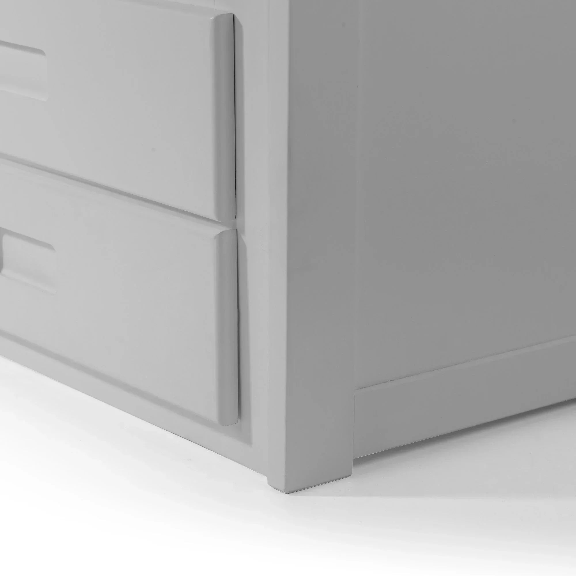 Close-up of white chest of drawers corner and handle detail