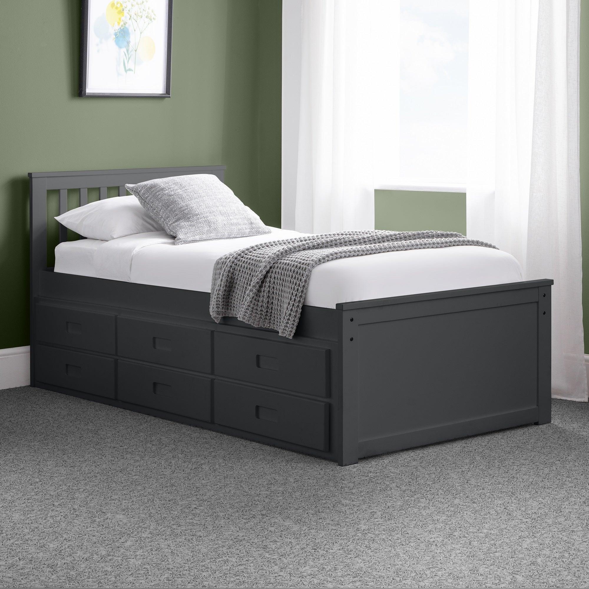 Anthracite single daybed with storage drawers in a modern bedroom with green walls