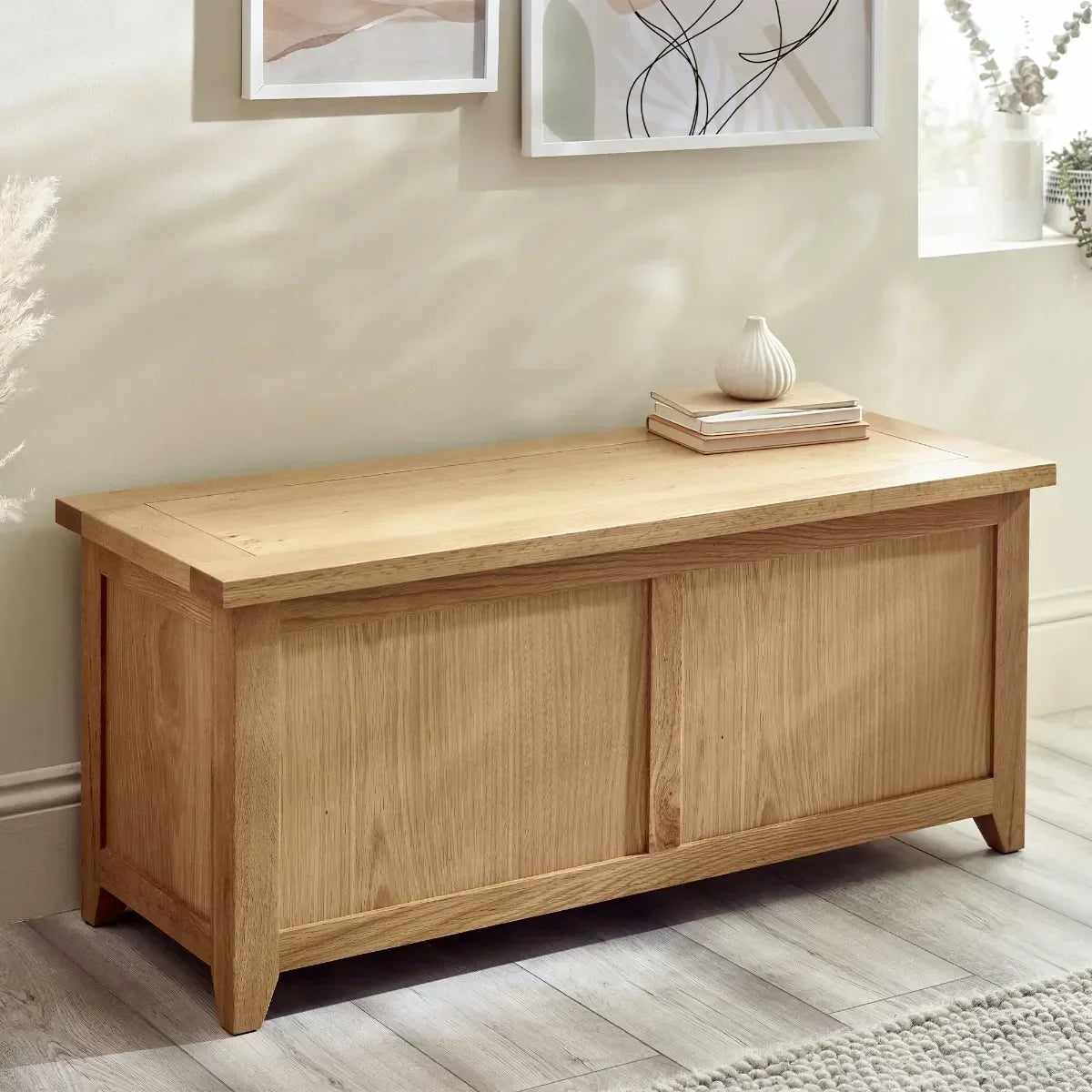 Oak storage bench with panel front and flat top in bright living room setting