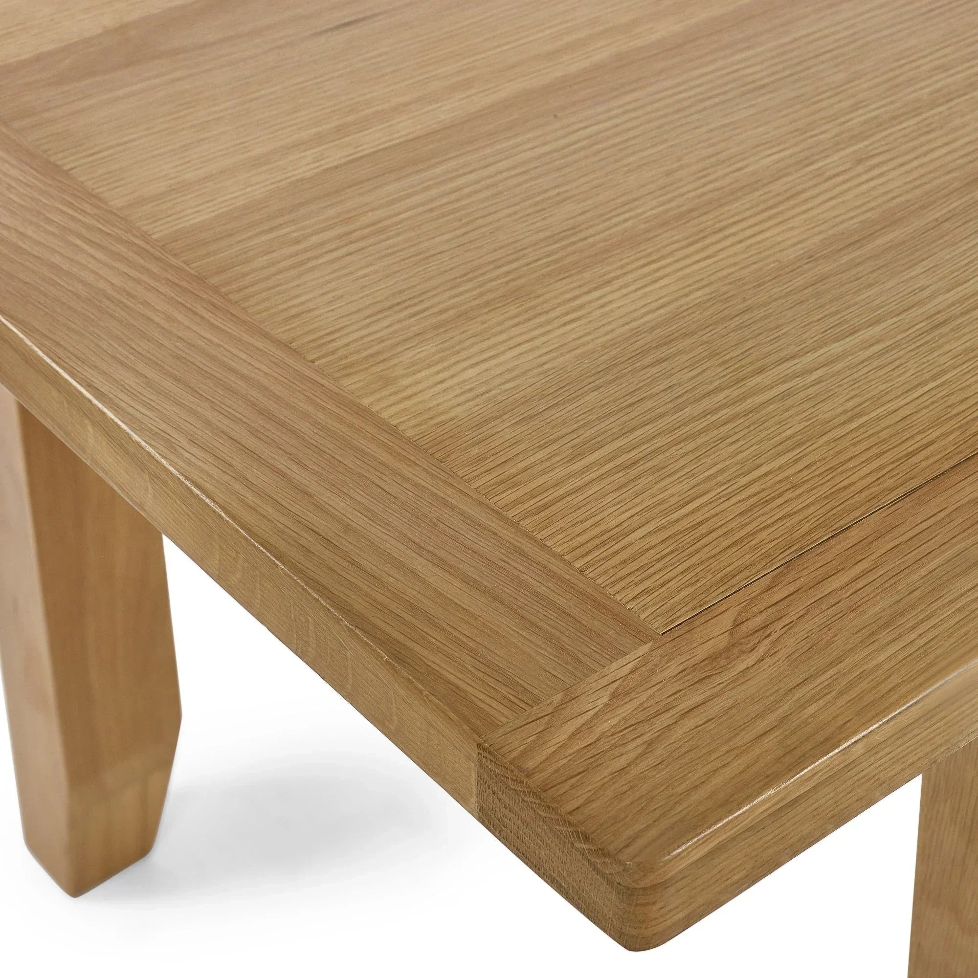 Oak dining table corner with visible wood grain and sturdy leg detail