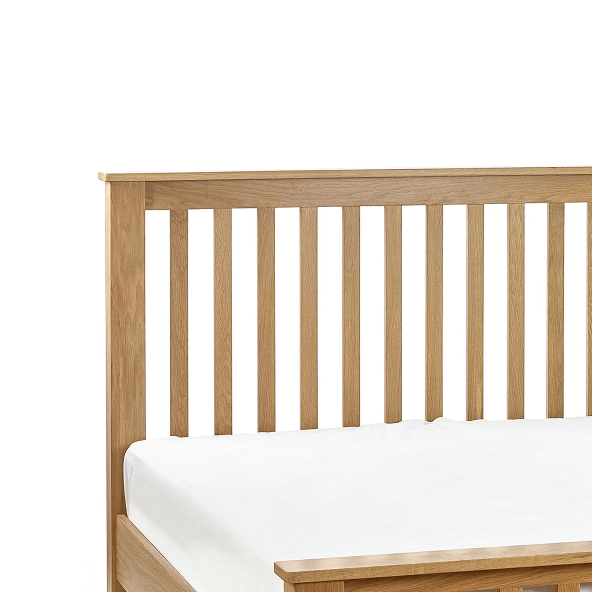 Oak double bed with slatted headboard and white mattress, close-up corner view