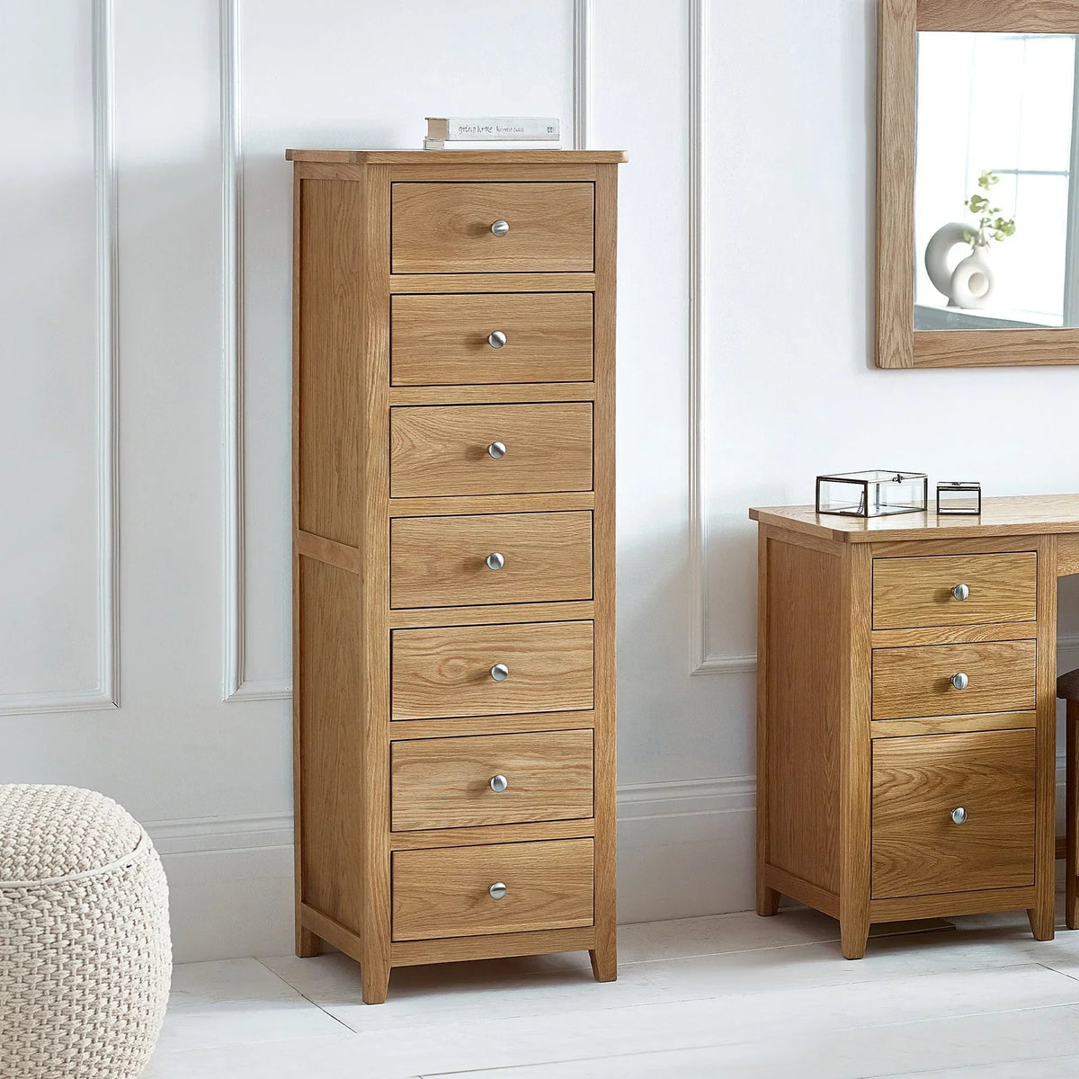 Oak narrow chest of drawers with seven drawers in modern bedroom setting