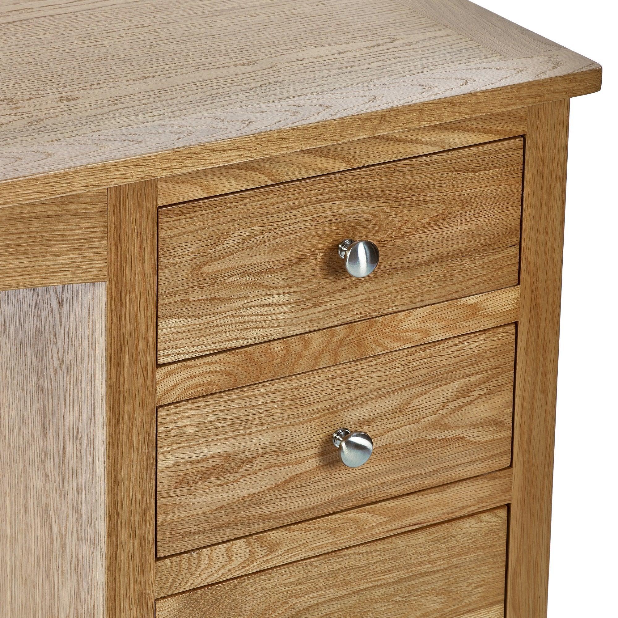 Oak dressing table with three drawers and silver handles, close-up of corner and wood grain