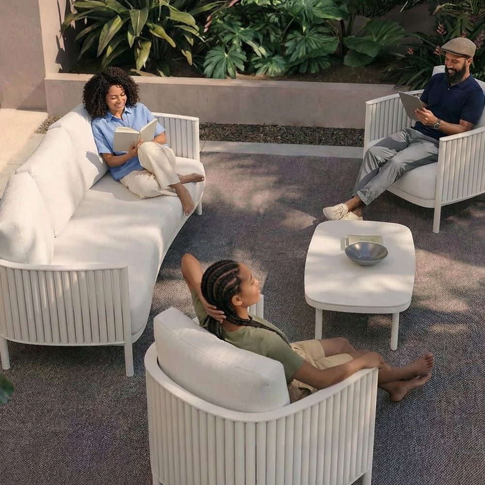 Image of White 5 seater outdoor lounging set with 3 people relaxing and reading