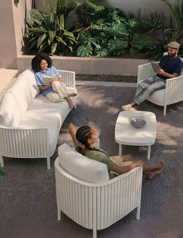 Image of White 5 seater outdoor lounging set with 3 people relaxing and reading