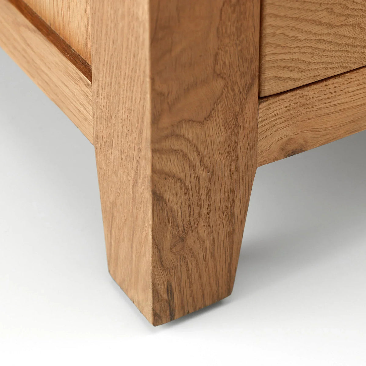 Close up of solid oak furniture leg with visible wood grain on white background