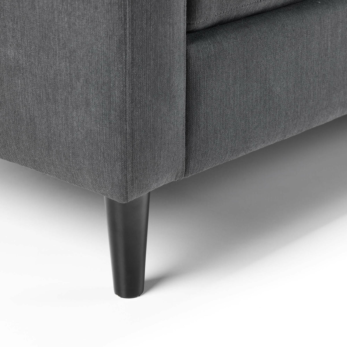 Dark grey corner sofa fabric with black tapered leg, close-up of base detail