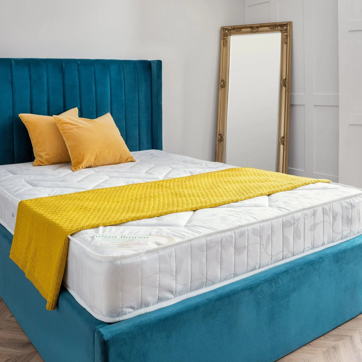 Deluxe semi-orthopaedic 150cm mattress on teal bed frame with yellow throw and pillows