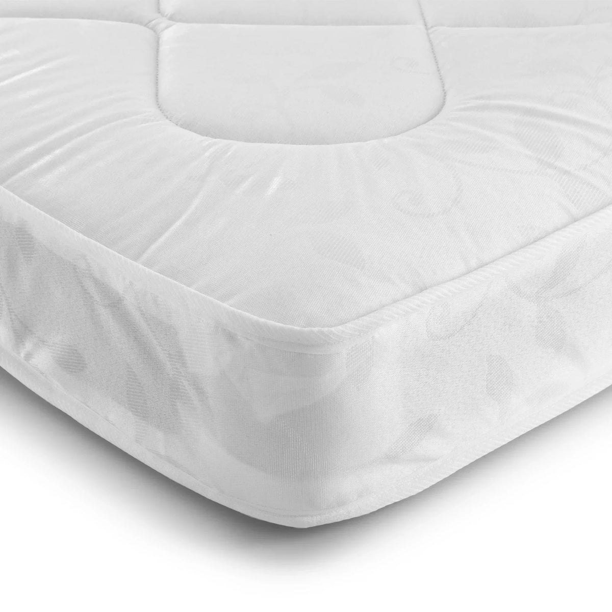 Corner detail of white 90cm mattress with quilted surface and subtle leaf pattern fabric