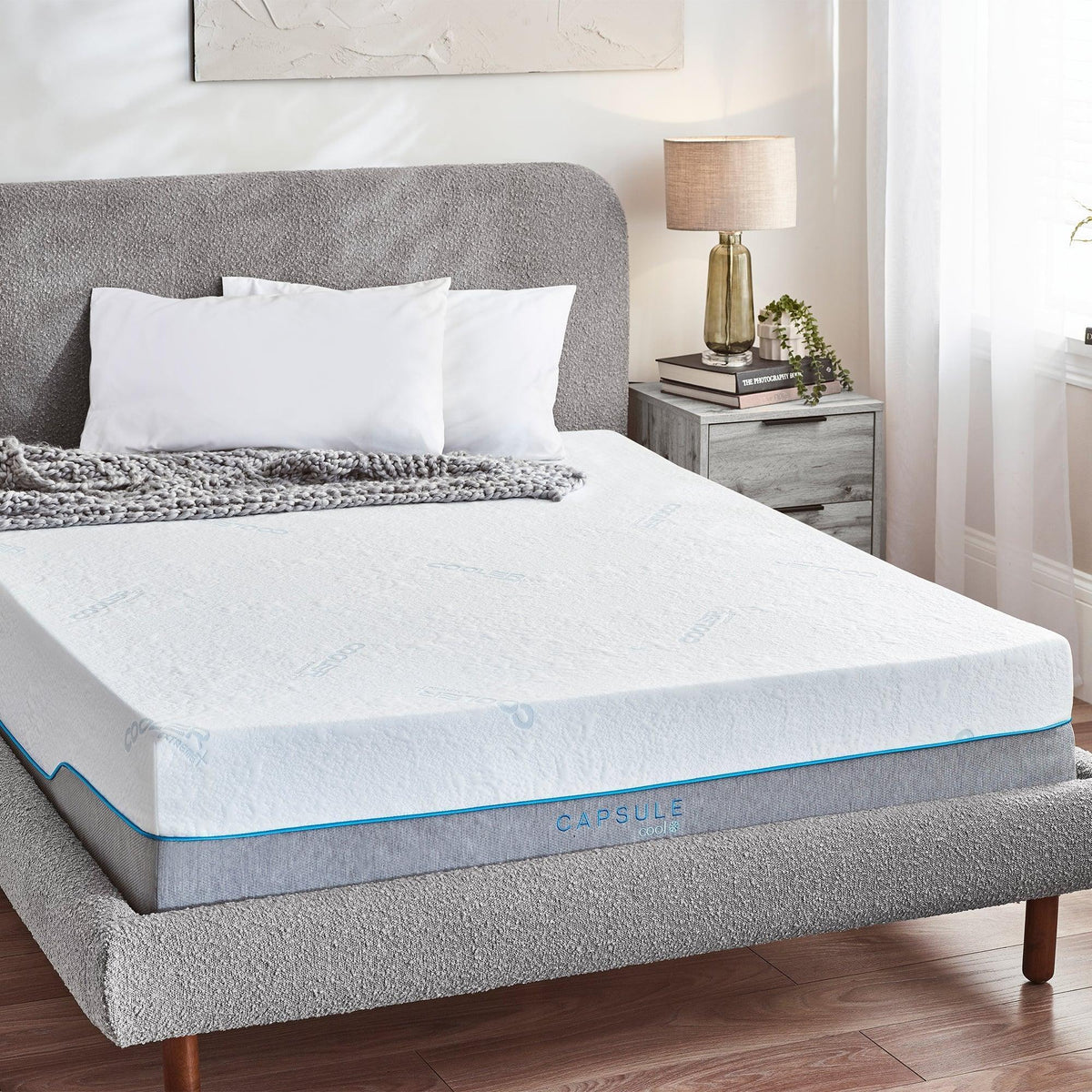 Capsule Cool mattress 150cm on grey upholstered bed with white pillows and grey throw