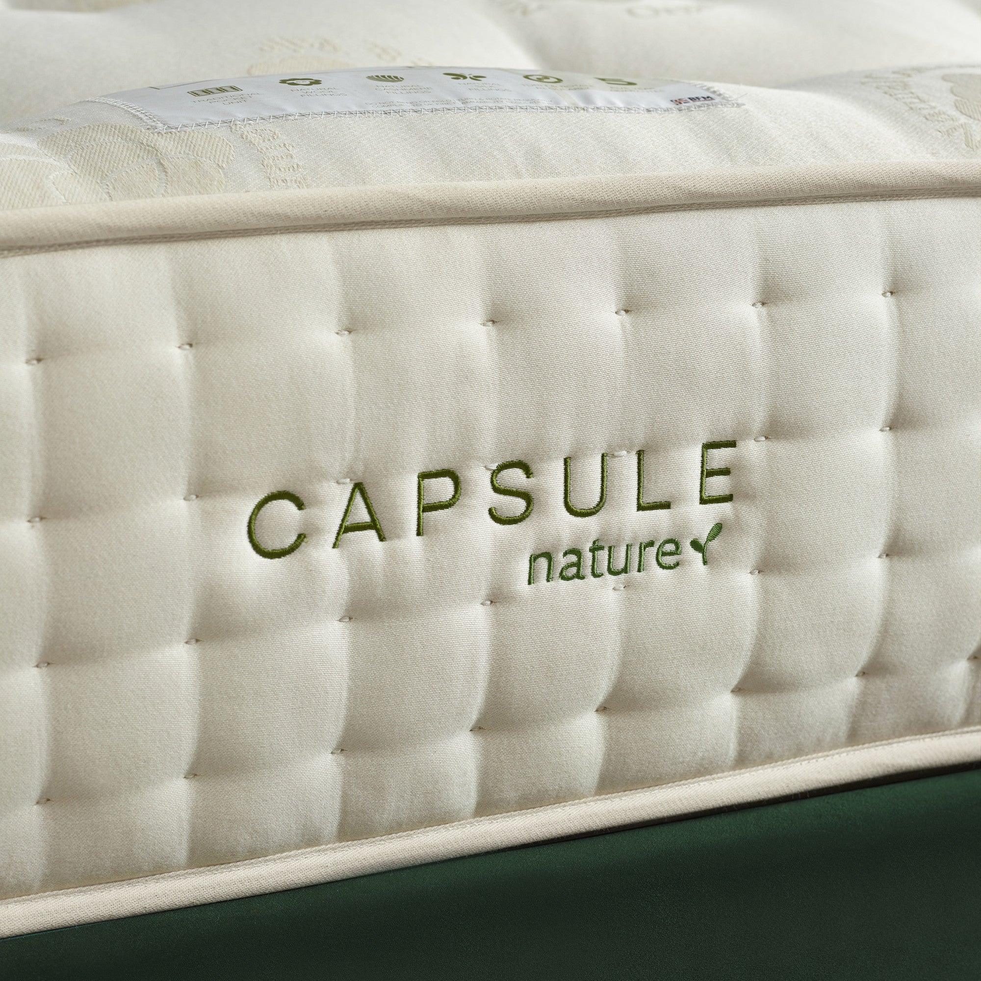 Closeup of Capsule Nature mattress corner with quilted fabric and stitched green logo