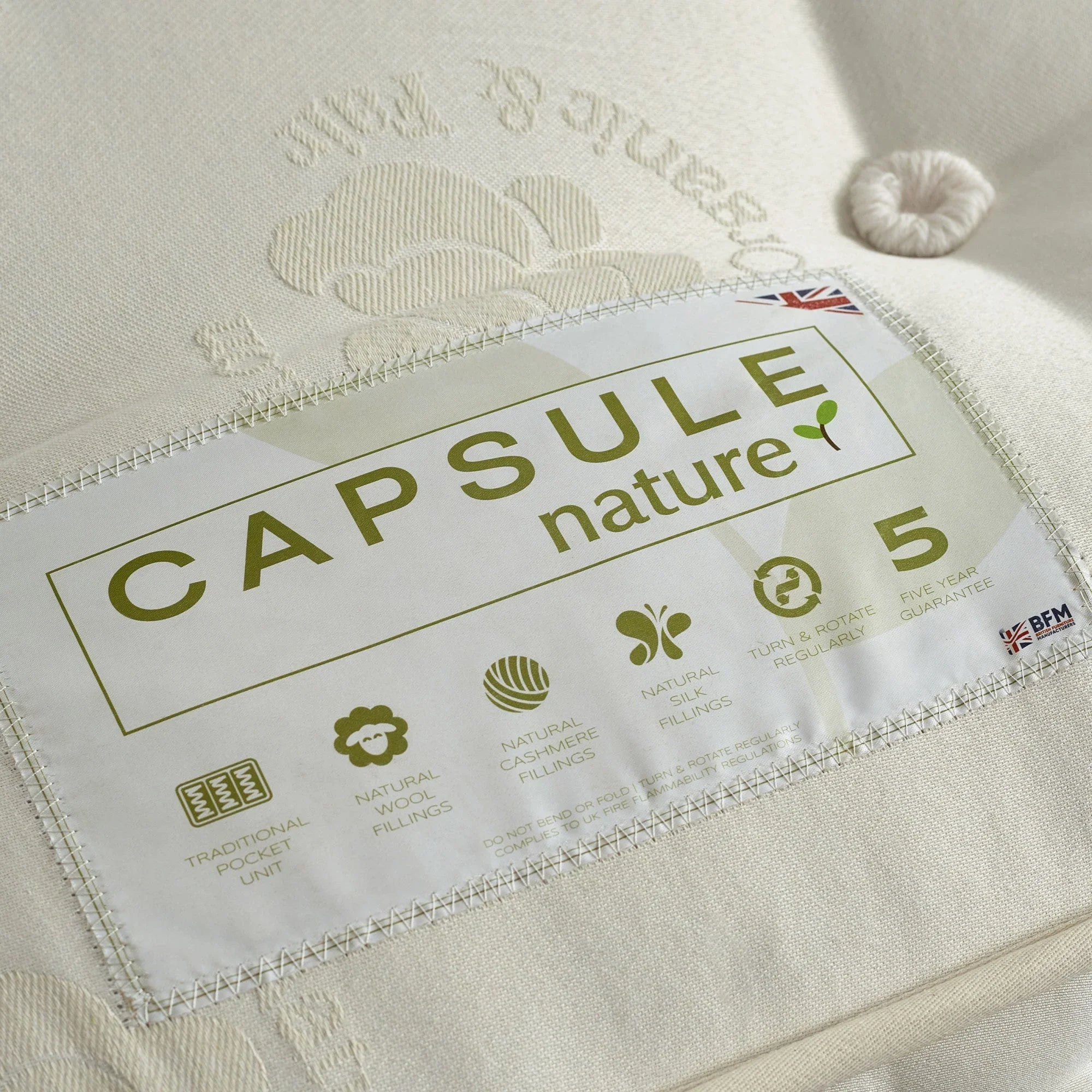 Capsule Nature mattress label showing natural wool and cashmere fillings, cream fabric close-up