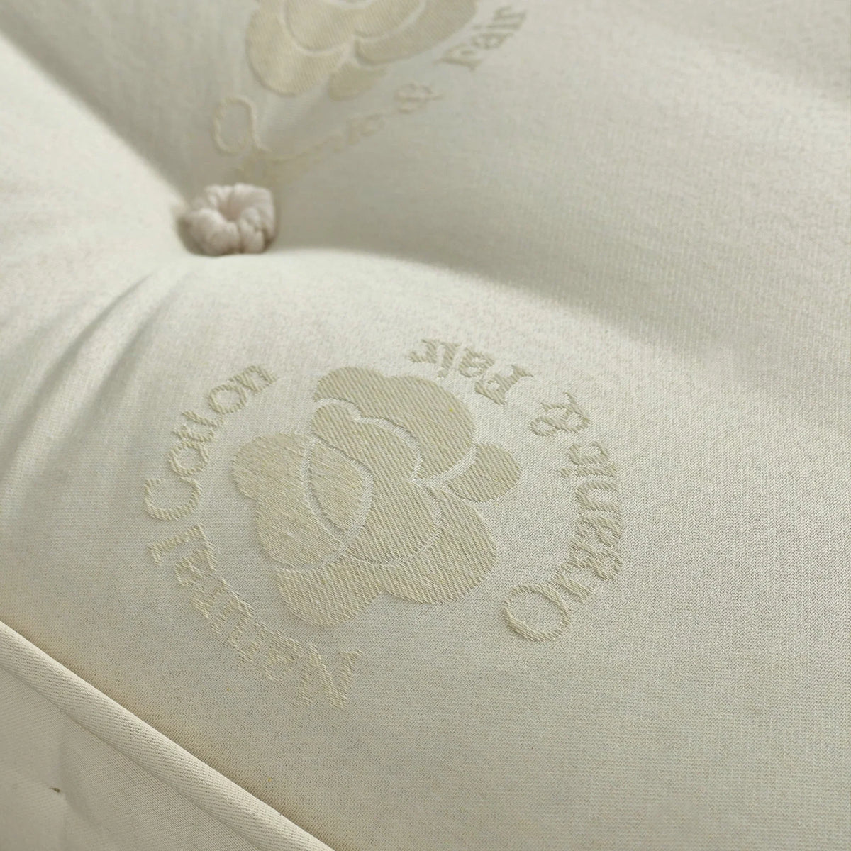 Natural cotton mattress surface with tufted button and floral embroidery detail