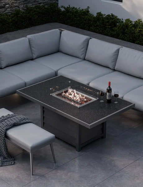 Grey garden corner sofa set with fire pit table, wine glasses and bottle on patio