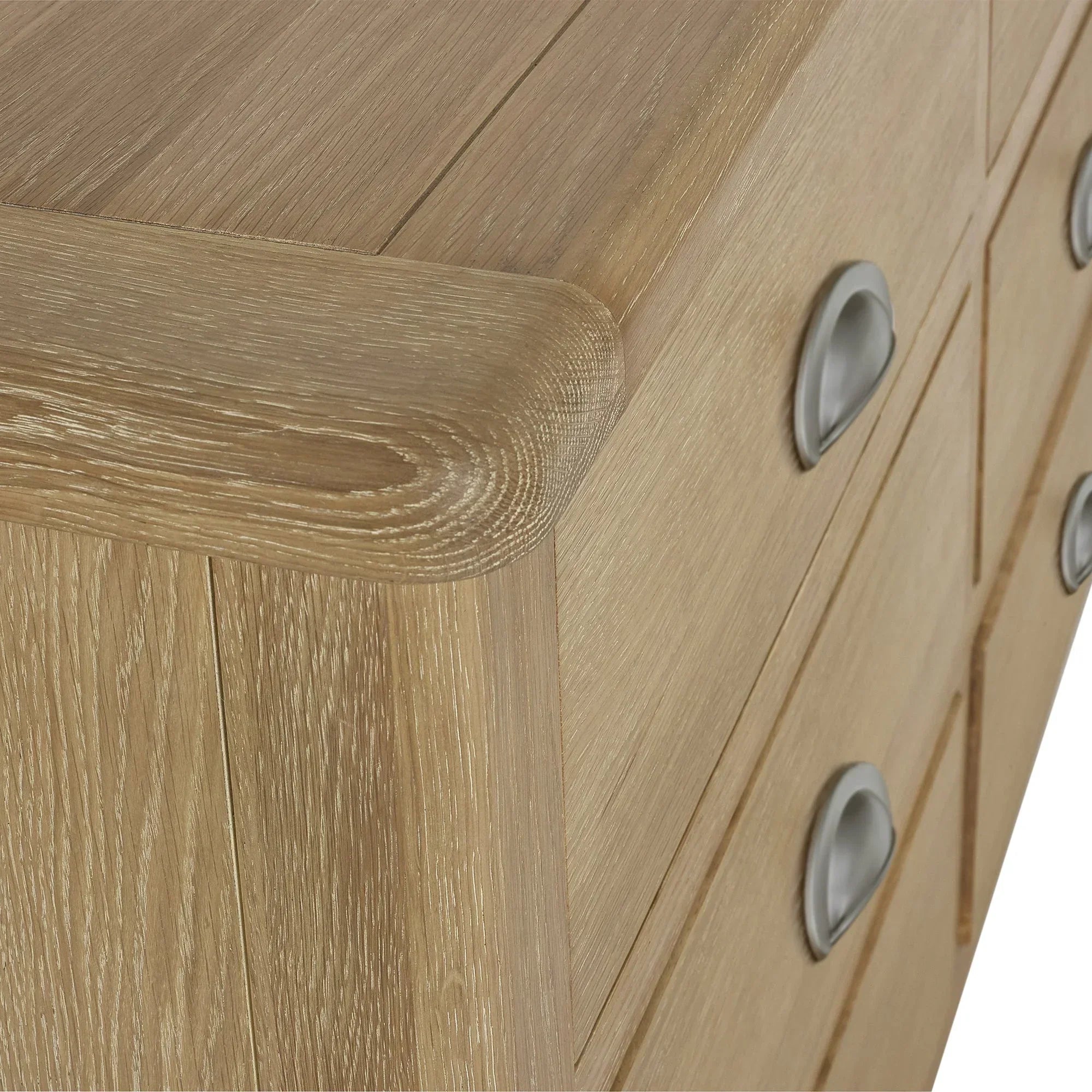 Close detail of limed oak 6 drawer chest with curved edge and silver cup handles