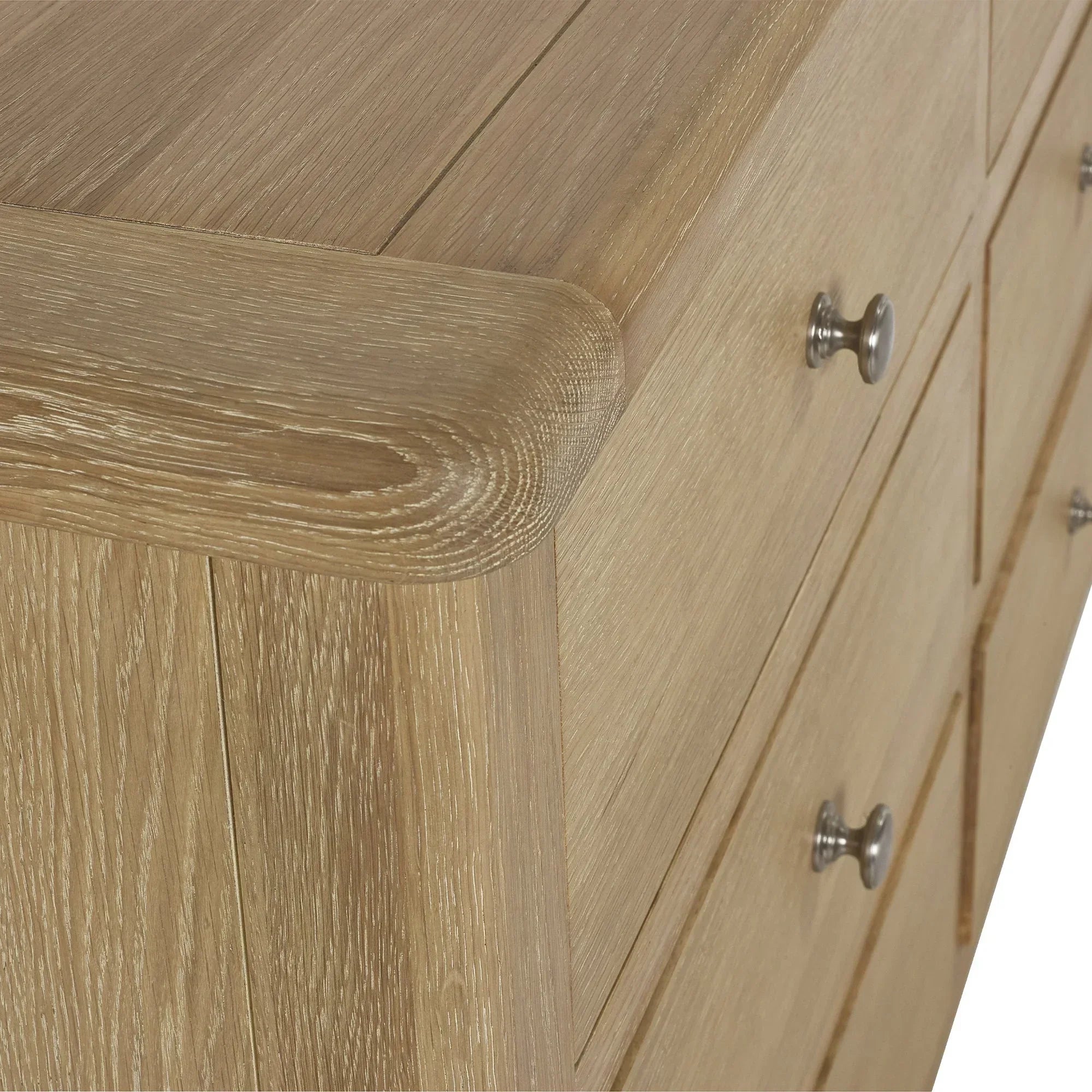 Close-up of limed oak chest of drawers with metal handles and wood grain detail