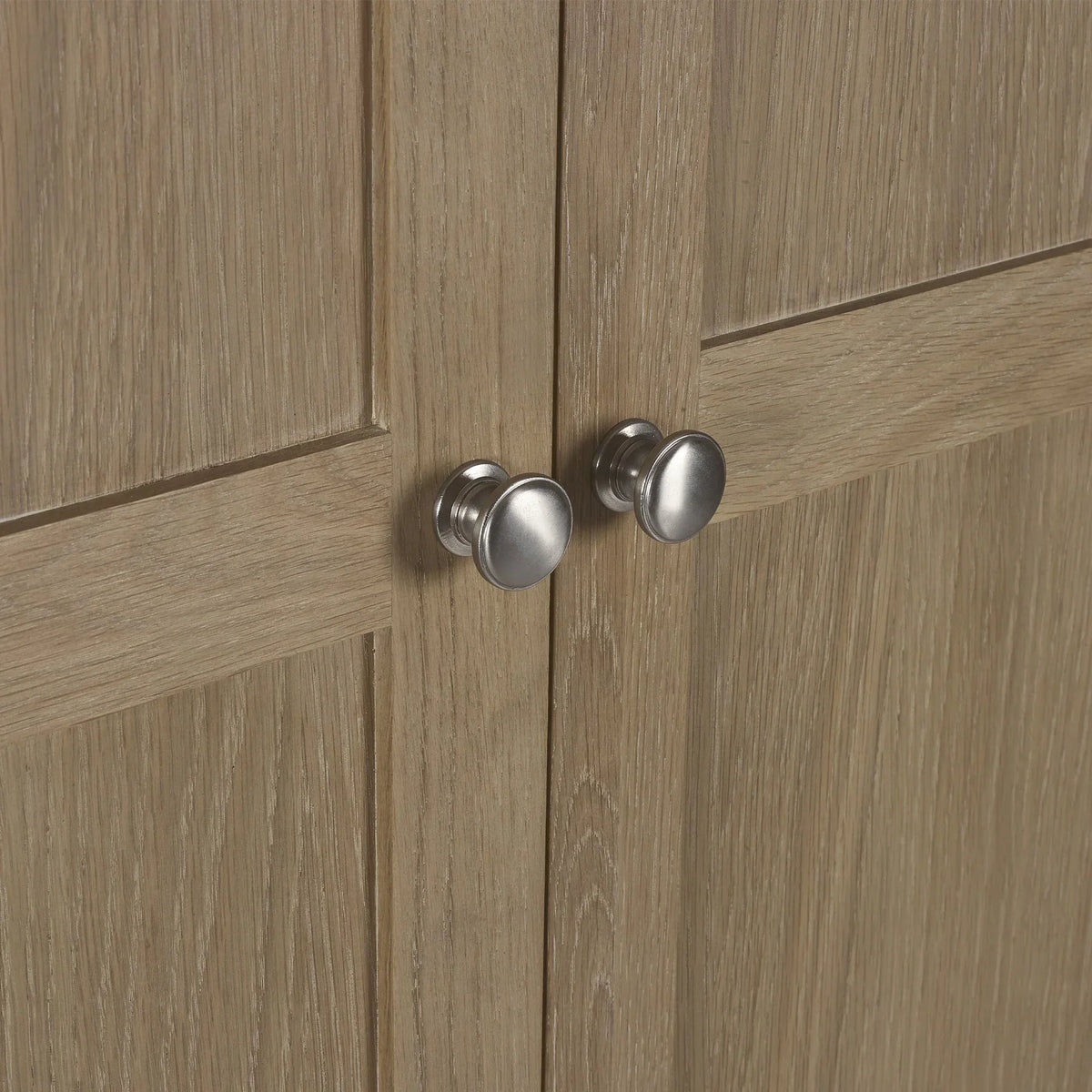 Close view of limed oak wardrobe doors with silver handles and wood grain texture