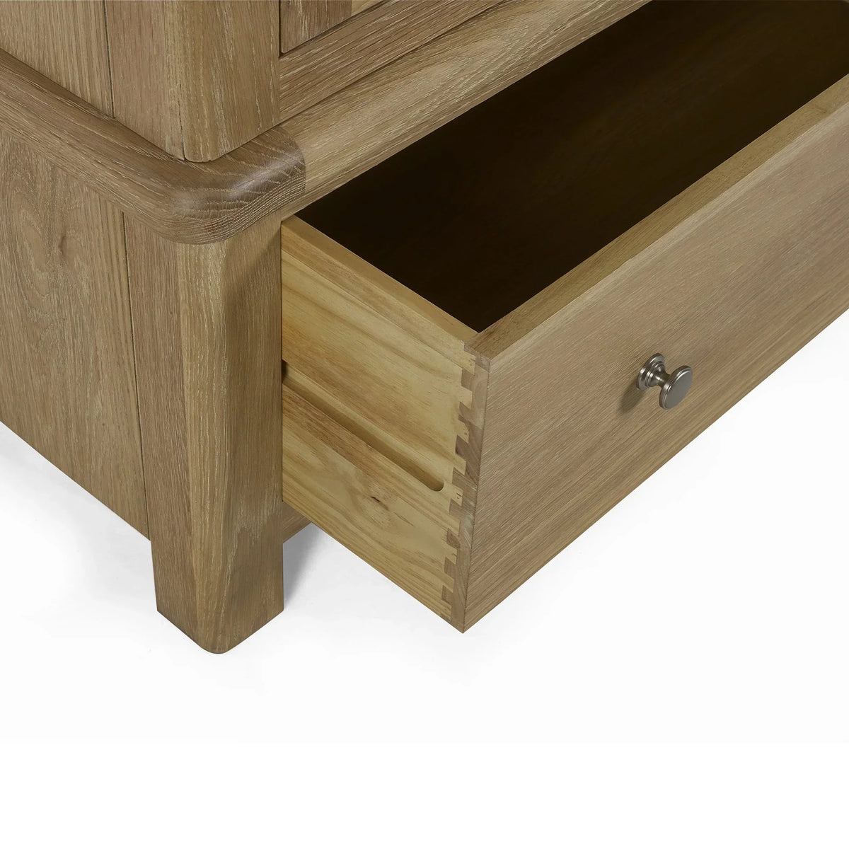 Detail of limed oak wardrobe lower drawer open showing dovetail joints and metal handle