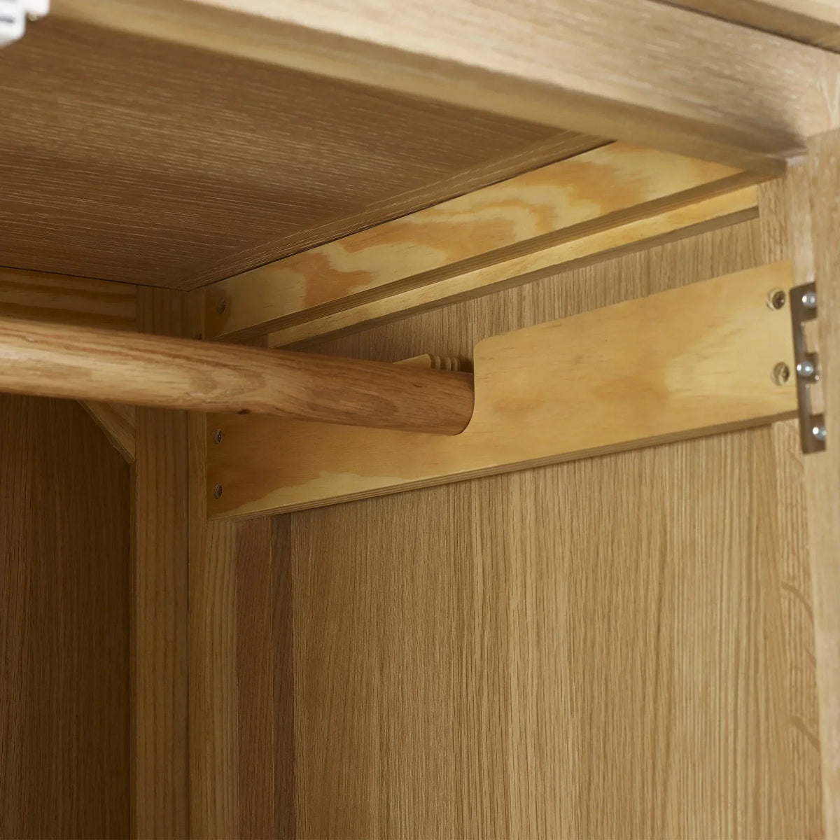 Limed oak wardrobe hanging rail detail with wood grain interior visible