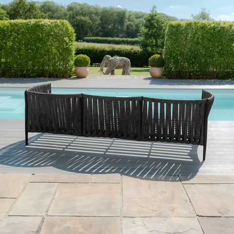 Charcoal outdoor sofa with woven rope back by a pool on a stone patio