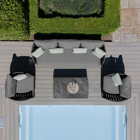 Grey outdoor sofa set with matching armchairs and low table by pool on deck