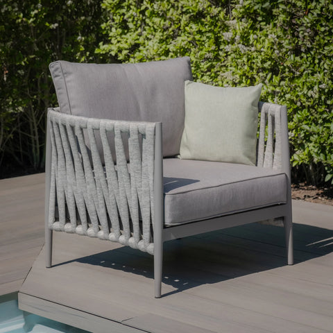 Grey outdoor armchair with rope sides and cushions on patio decking