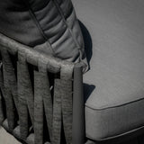 Close up of grey outdoor chair with woven rope backrest and textured seat cushion