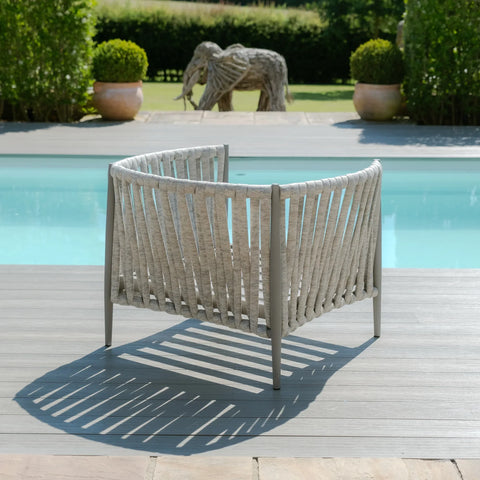 Outdoor rope lounge chair in grey on decking beside a swimming pool